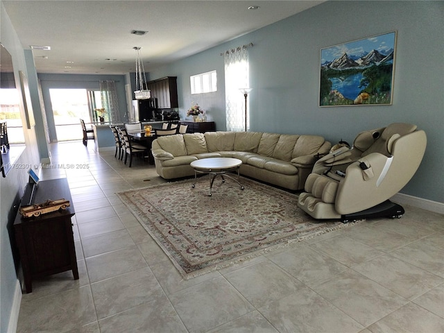 living area featuring light tile patterned floors, baseboards, and visible vents