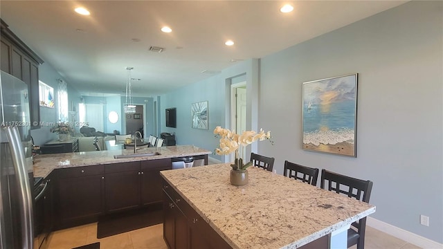 kitchen with visible vents, a breakfast bar, recessed lighting, a peninsula, and a sink