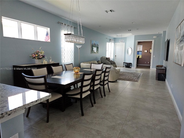 dining room featuring tile patterned flooring, baseboards, and visible vents