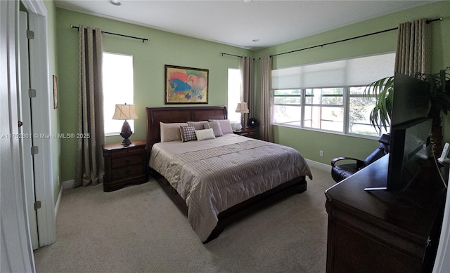 bedroom with baseboards and light carpet