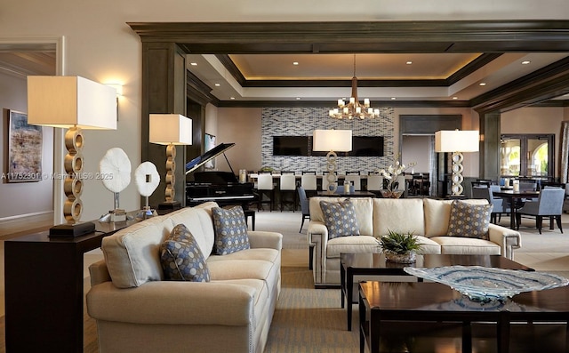 living room featuring recessed lighting, a tray ceiling, a chandelier, and crown molding