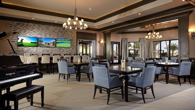 dining room featuring an accent wall, an inviting chandelier, plenty of natural light, and crown molding