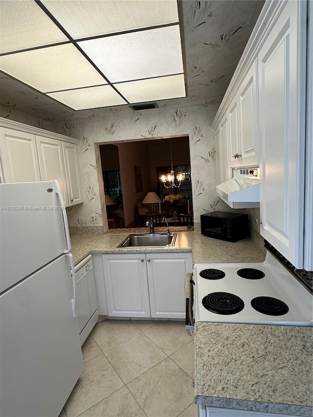 kitchen featuring white appliances, a chandelier, light countertops, white cabinetry, and a sink