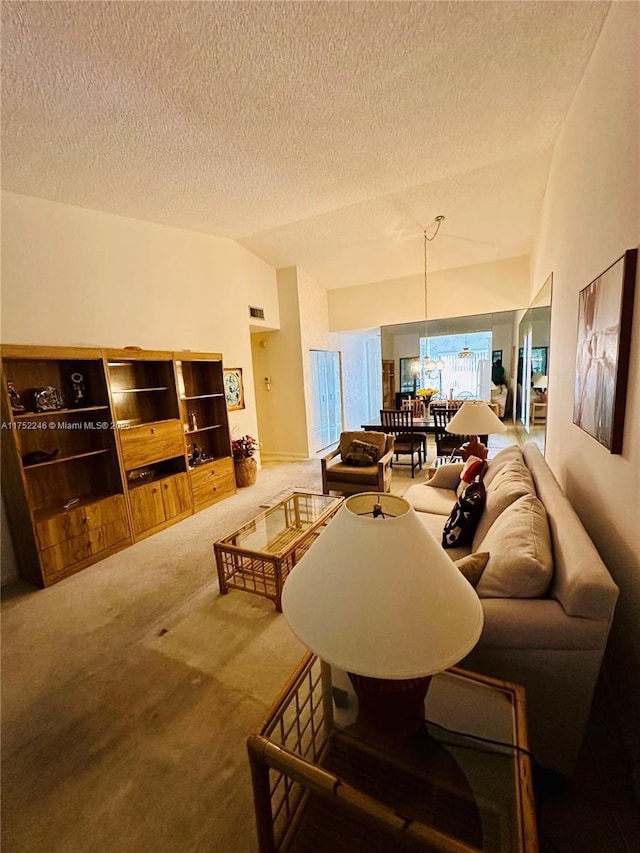 carpeted living area with lofted ceiling, a textured ceiling, and visible vents