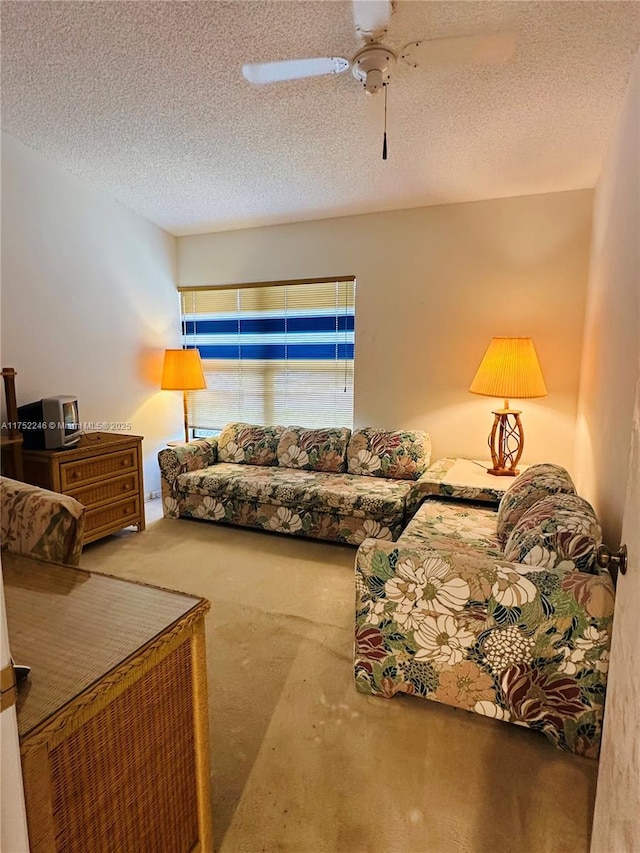 living area with carpet flooring, ceiling fan, and a textured ceiling