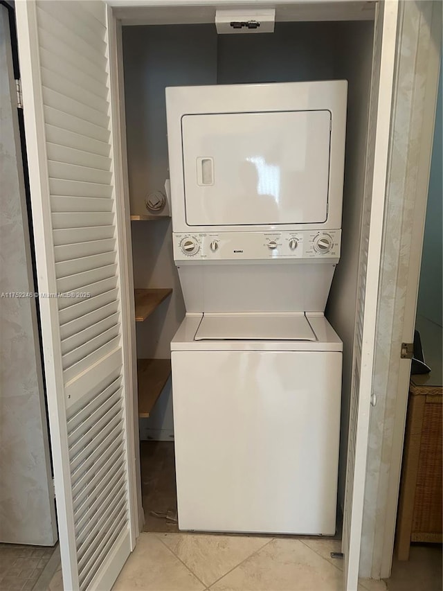 clothes washing area featuring stacked washer / drying machine and laundry area