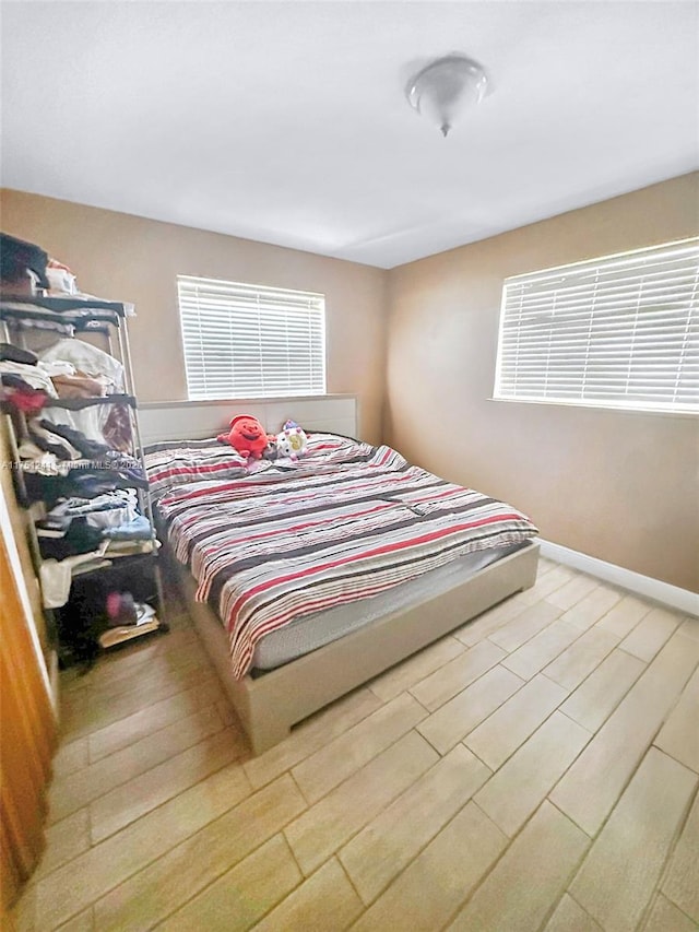 bedroom featuring baseboards and wood finished floors