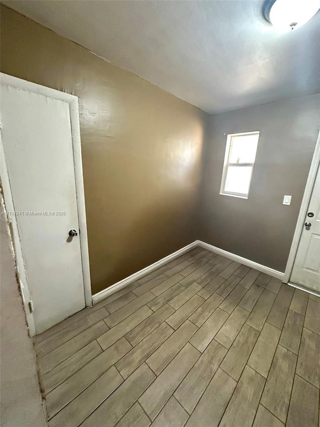 unfurnished room featuring wood finish floors and baseboards