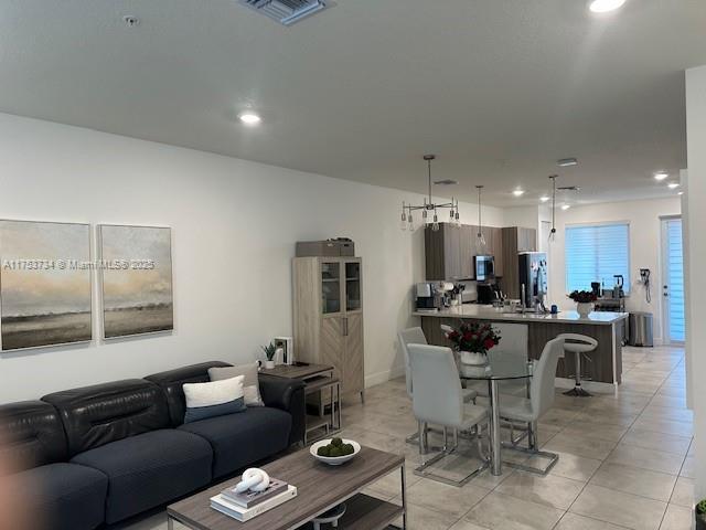 living room with recessed lighting, visible vents, and light tile patterned flooring