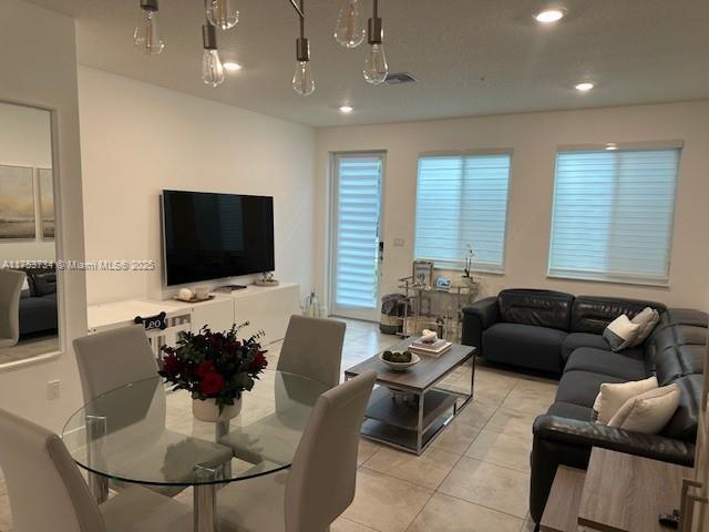 living area featuring recessed lighting, visible vents, and light tile patterned flooring