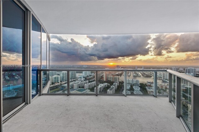 balcony at dusk featuring a view of city