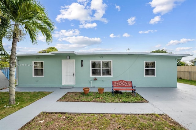 view of front of property with fence and stucco siding