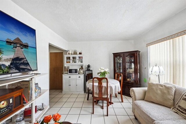 dining area featuring light tile patterned floors and a textured ceiling