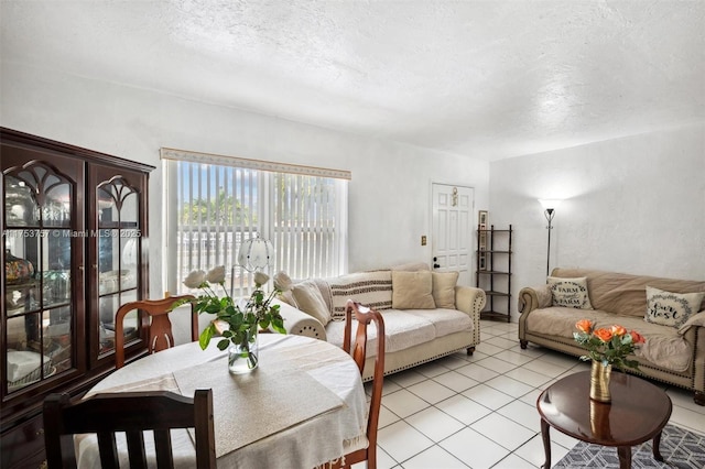 living room with a textured ceiling and light tile patterned flooring