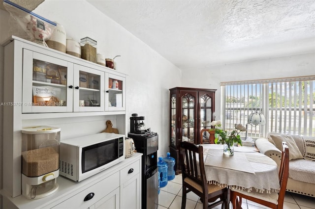 dining area with a textured ceiling and light tile patterned floors