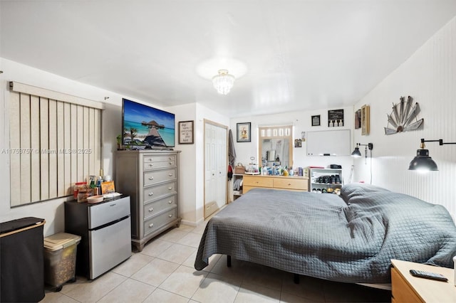 bedroom with freestanding refrigerator and light tile patterned floors