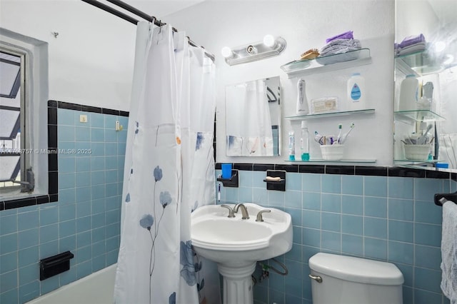 full bathroom featuring wainscoting, shower / tub combo with curtain, tile walls, and toilet