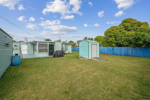 view of yard featuring a storage unit, an outdoor structure, and a fenced backyard