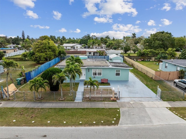 view of front facade with a fenced front yard, a gate, concrete driveway, and a front yard