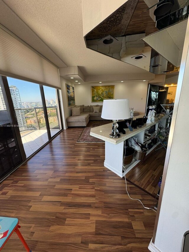 living area with visible vents, a textured ceiling, and wood finished floors