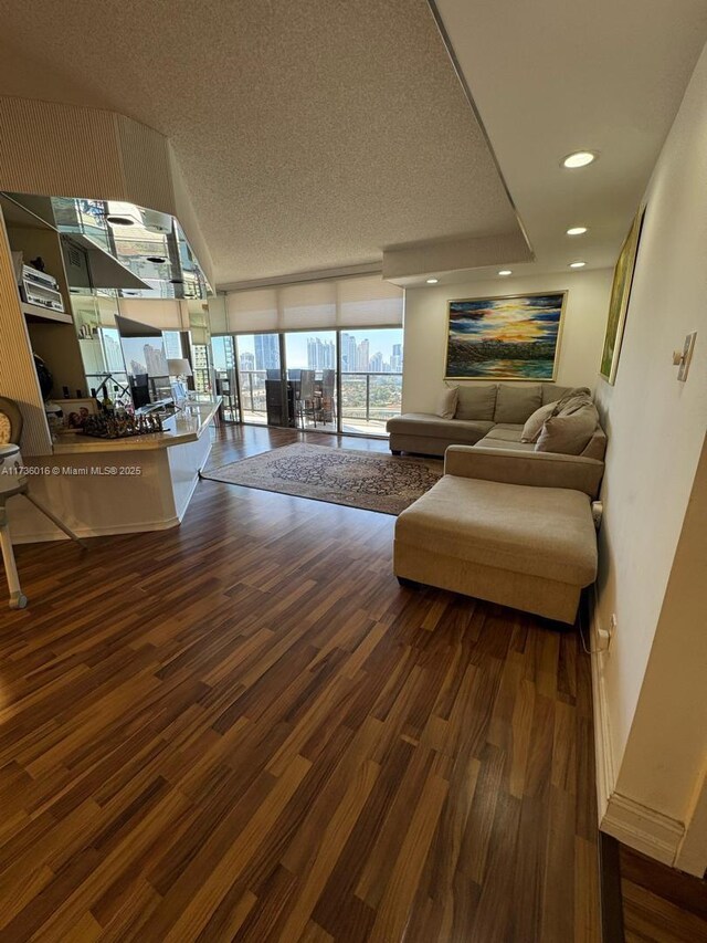 living room featuring expansive windows, a textured ceiling, recessed lighting, and wood finished floors