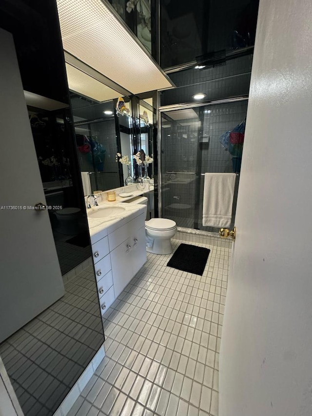 full bath with a stall shower, tile patterned flooring, vanity, and toilet