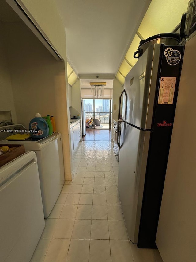 clothes washing area with light tile patterned floors, laundry area, and washer and dryer