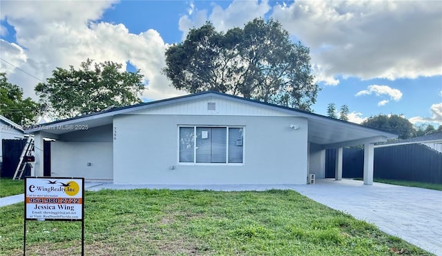 view of property exterior featuring driveway, fence, an attached carport, and a yard