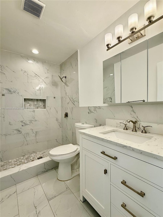 full bathroom with toilet, vanity, visible vents, marble finish floor, and a marble finish shower