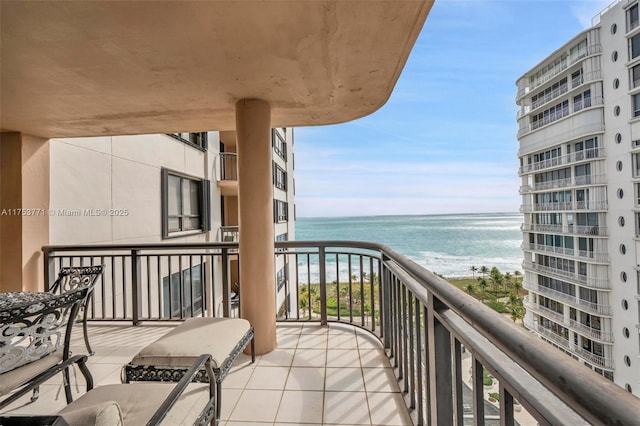 balcony featuring a water view and a beach view