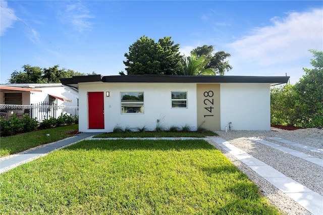 single story home with a front yard, fence, and stucco siding