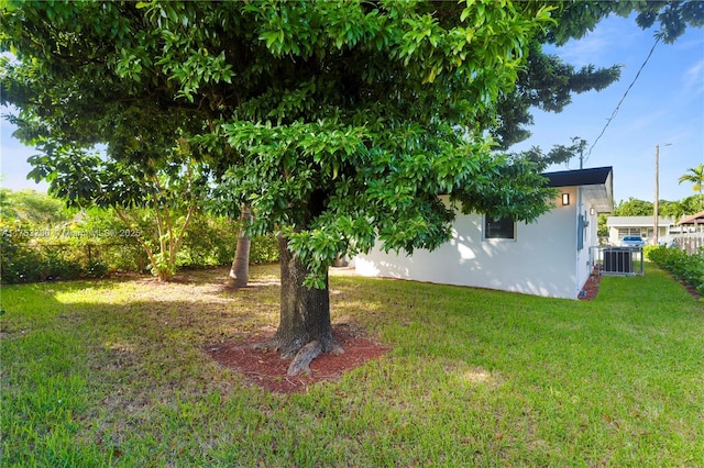 view of yard featuring central air condition unit and fence