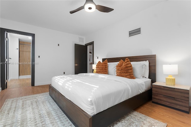 bedroom featuring visible vents, baseboards, light wood-style floors, and a ceiling fan