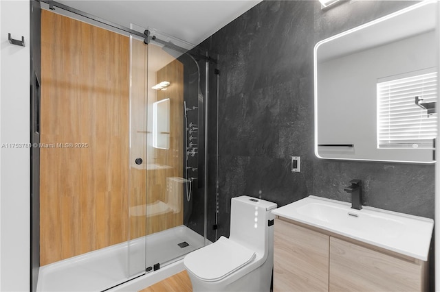 bathroom featuring tile walls, a shower stall, toilet, and vanity