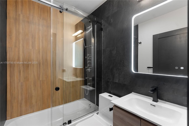 full bathroom with vanity, tile walls, tasteful backsplash, and bath / shower combo with glass door