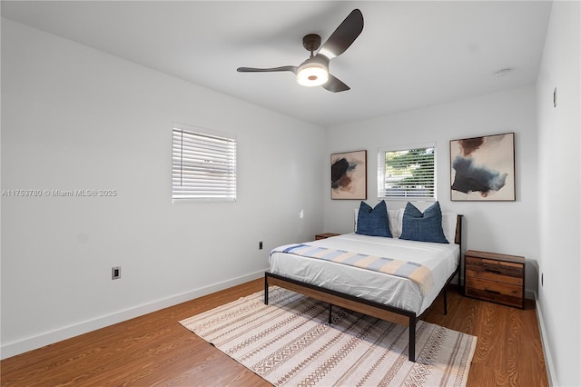 bedroom with a ceiling fan, baseboards, and wood finished floors