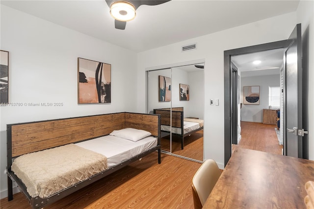 bedroom featuring a closet, visible vents, ceiling fan, and light wood-style floors