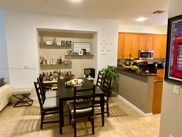 dining space with light tile patterned floors, visible vents, and baseboards