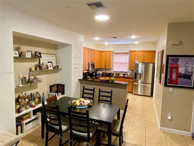 dining space with baseboards, visible vents, and light tile patterned flooring