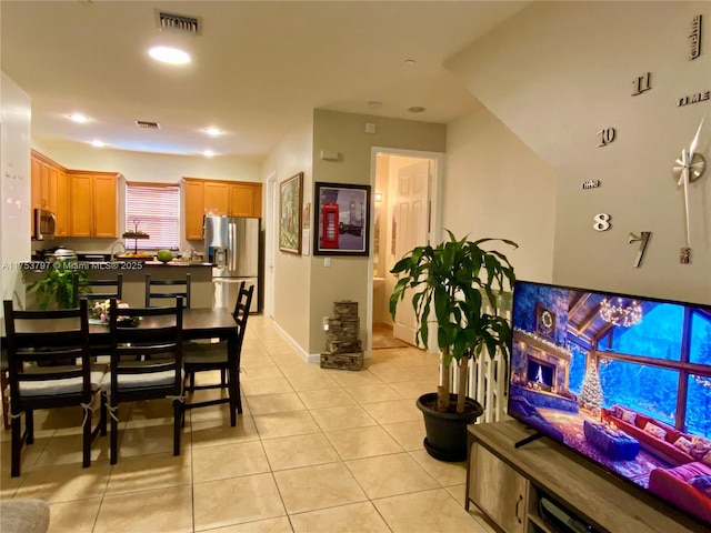 dining space featuring light tile patterned floors, visible vents, and baseboards