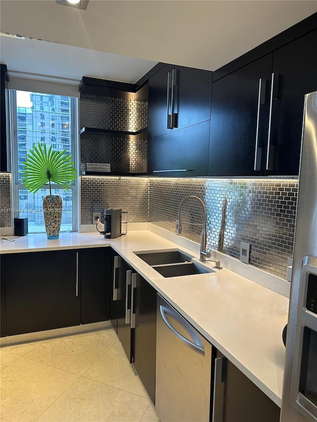 kitchen with decorative backsplash, a sink, and dark cabinets