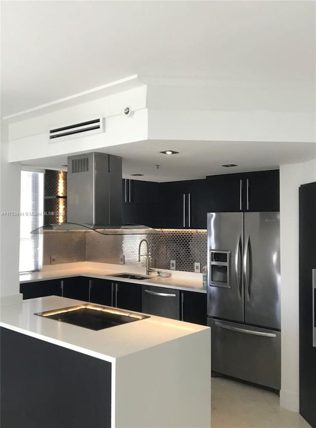 kitchen featuring light countertops, appliances with stainless steel finishes, a sink, and dark cabinets