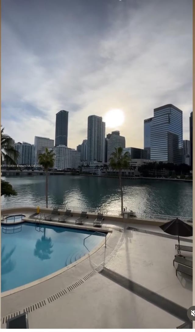 view of pool with a water view and a view of city