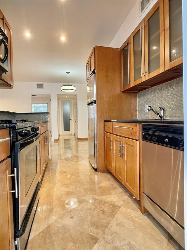 kitchen with dark countertops, brown cabinets, and stainless steel appliances