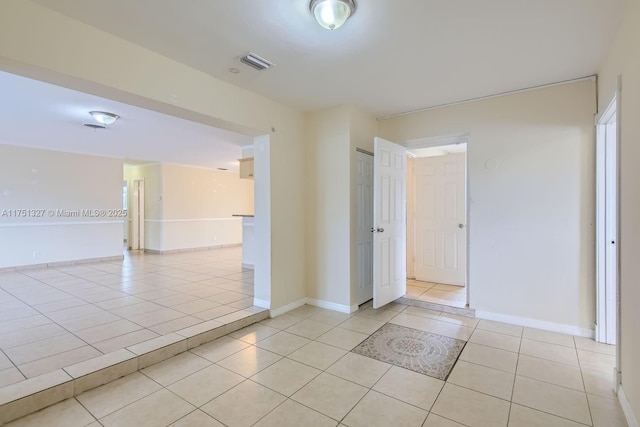 unfurnished room with visible vents, baseboards, and light tile patterned floors