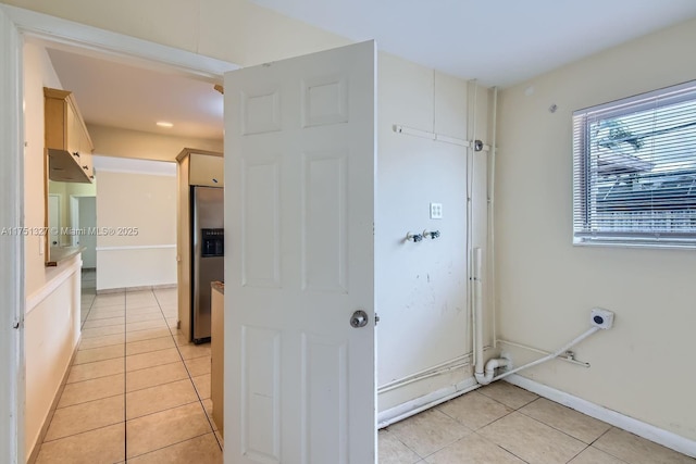 laundry room featuring baseboards and light tile patterned floors