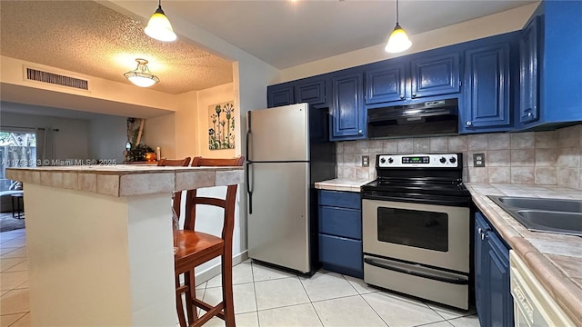 kitchen with under cabinet range hood, appliances with stainless steel finishes, and blue cabinets