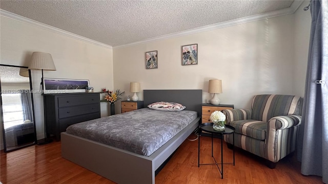 bedroom with a textured ceiling, ornamental molding, and wood finished floors