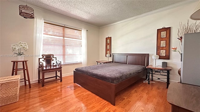 bedroom with a textured ceiling, baseboards, wood finished floors, and crown molding