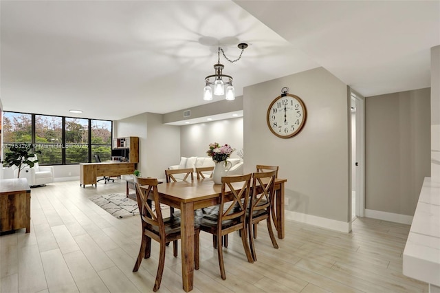 dining room with light wood-style floors, visible vents, baseboards, and a chandelier